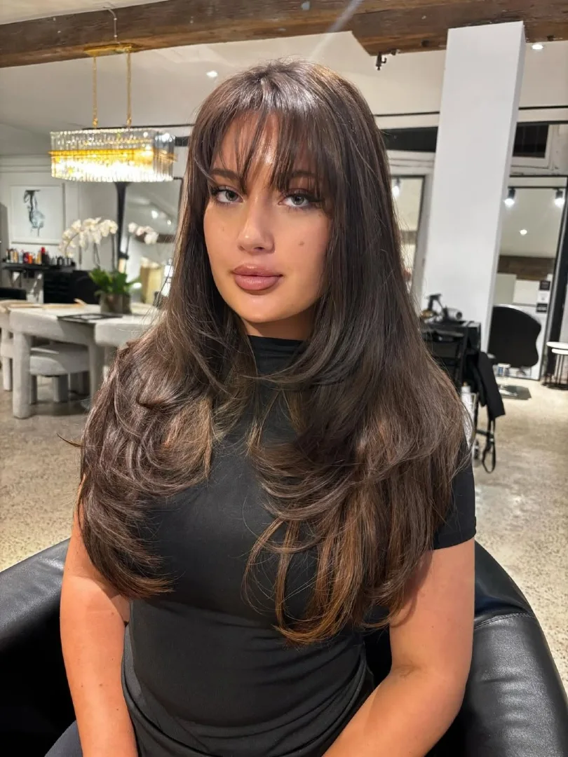 Deep Brown Layered Hair with Fringe Bangs and Caramel Peekaboo Highlights
