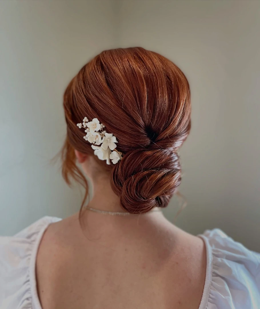 Sleek Auburn Low Chignon with Floral Hair Pin