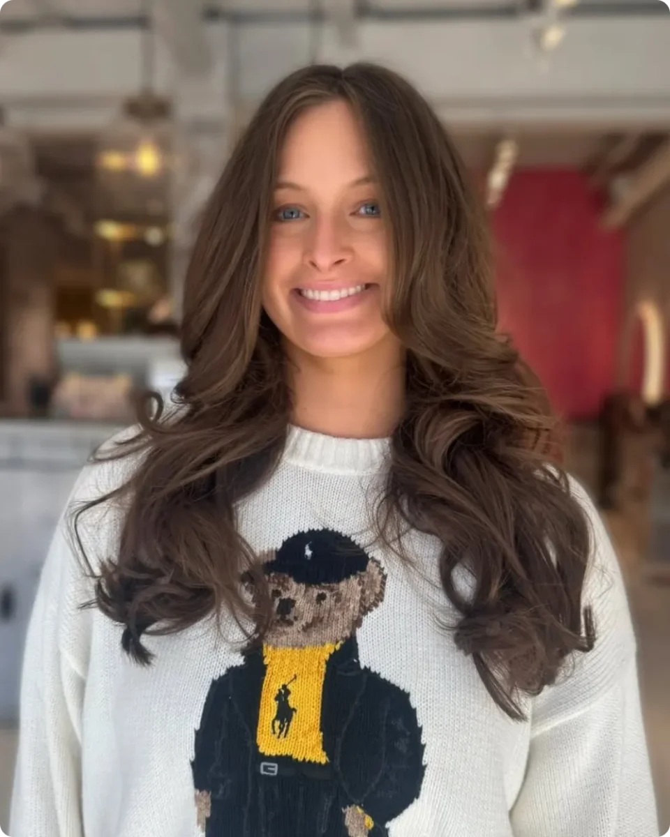 Chestnut brown hair with layers starting below the shoulders and no face framing