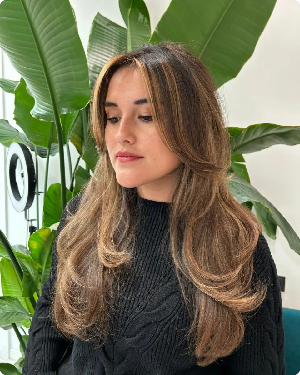 Curtain layers on brown hair with caramel highlights running through the front sections