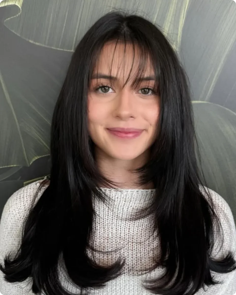See through bangs on long black hair with layers only at the ends turning outward