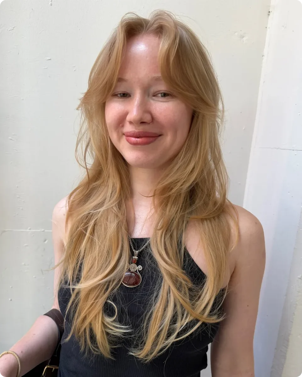 Strawberry blonde layers left loose with a natural wave and softly pointed ends