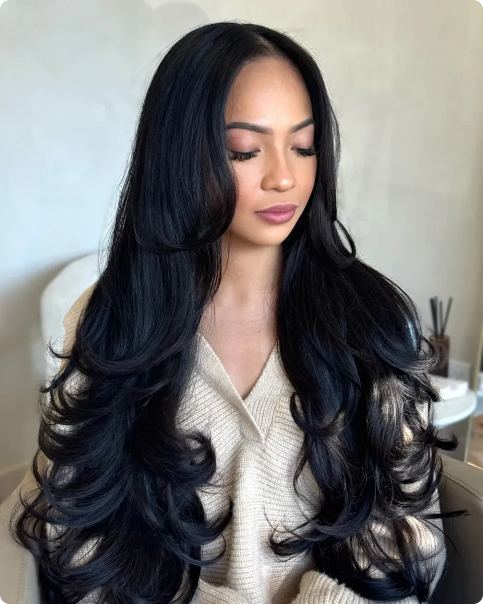 Waist length black hair with smooth lengths and defined spiral curls in the last third