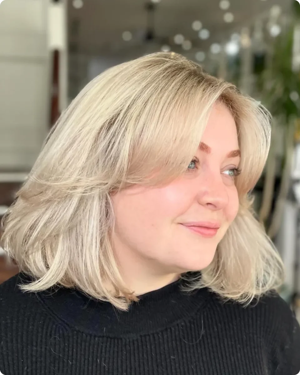 Soft blonde bob with long side-swept bangs and lift through the roots