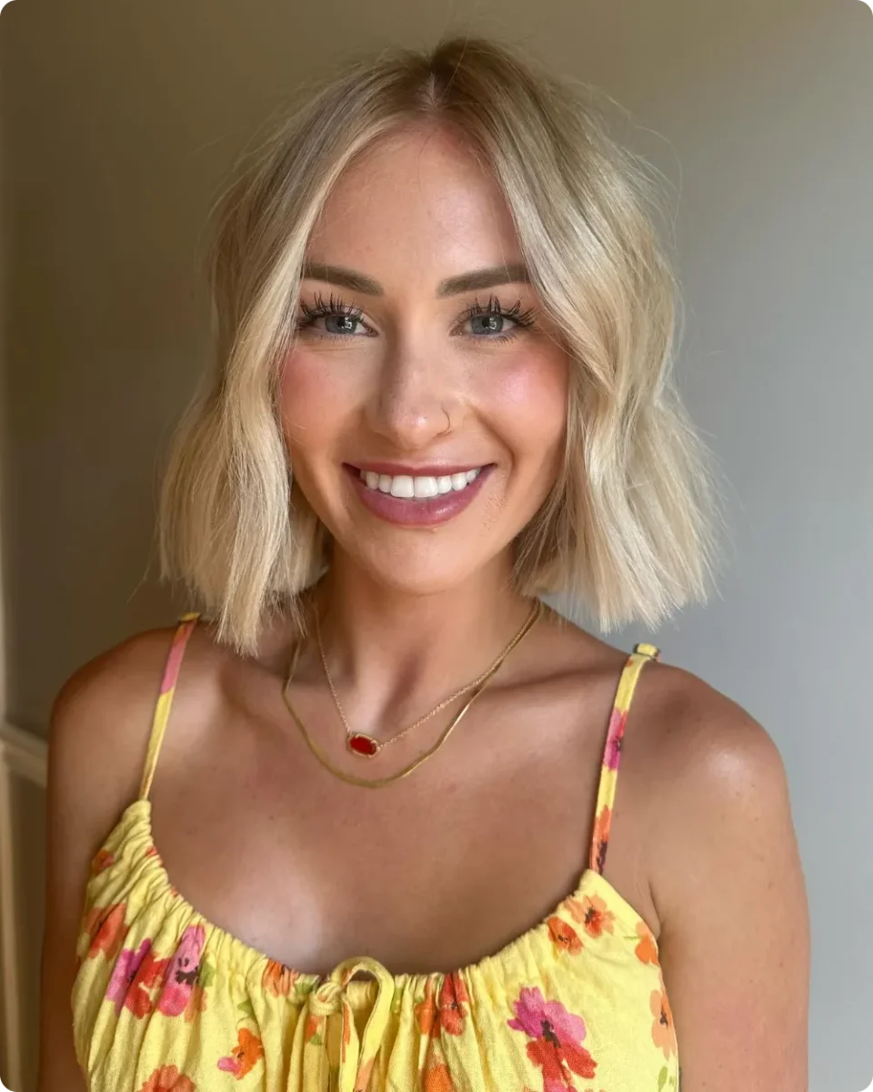 Blonde jaw-length blunt bob with loose undone waves and a middle part