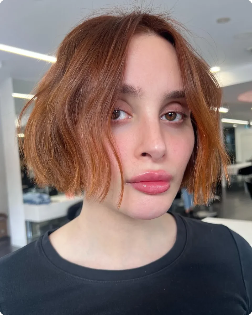 Copper chin-length bob with roughed-up uneven ends and a middle part