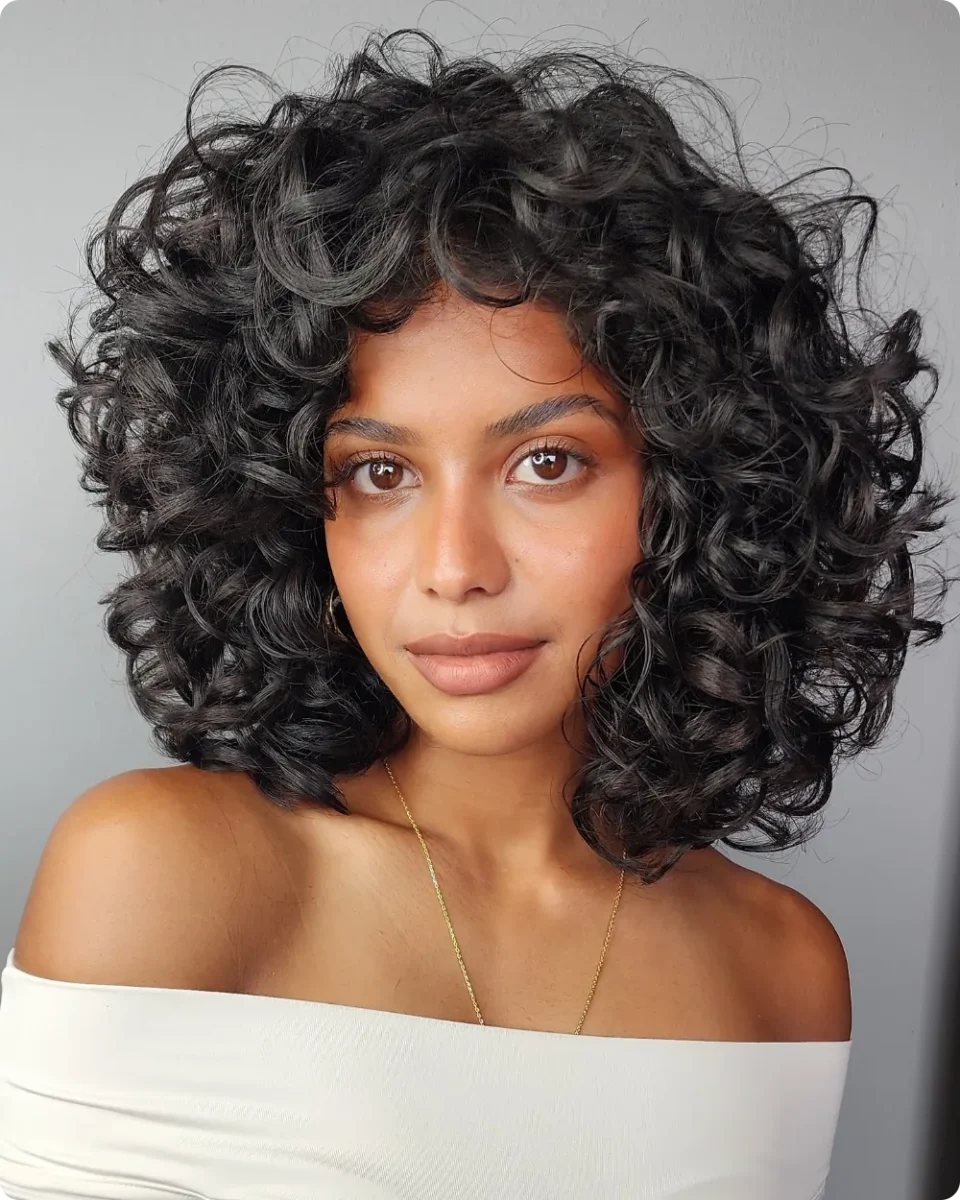 Full dark curly bob shaped into a rounded silhouette with defined curls