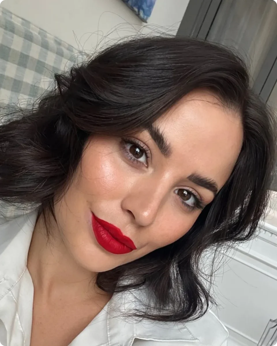 Dark brown bob with a deep side part and large bouncy bends at the ends