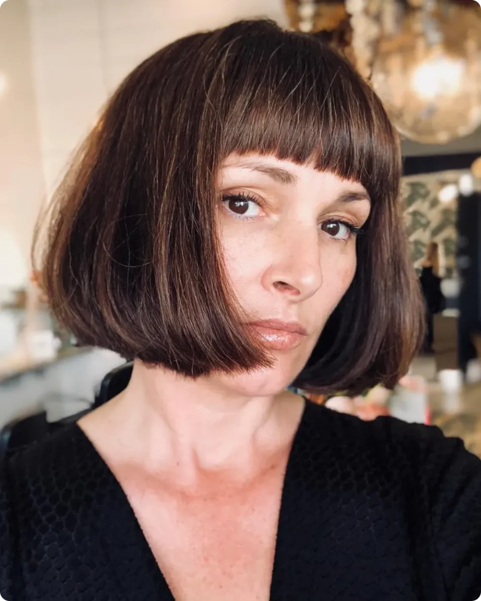 Rounded chestnut brown French bob with a short straight fringe
