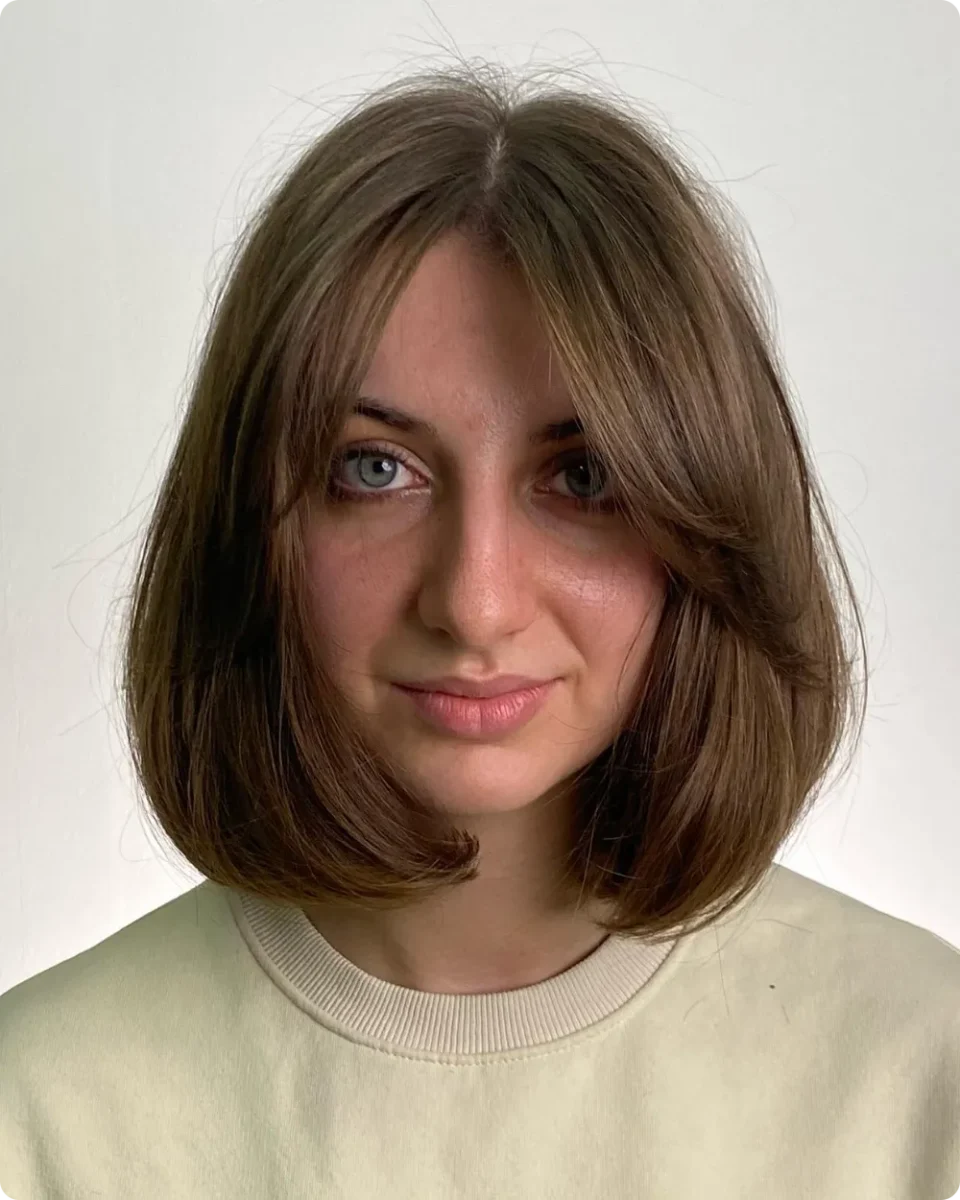 Brown middle-part bob with curtain bangs falling into the length