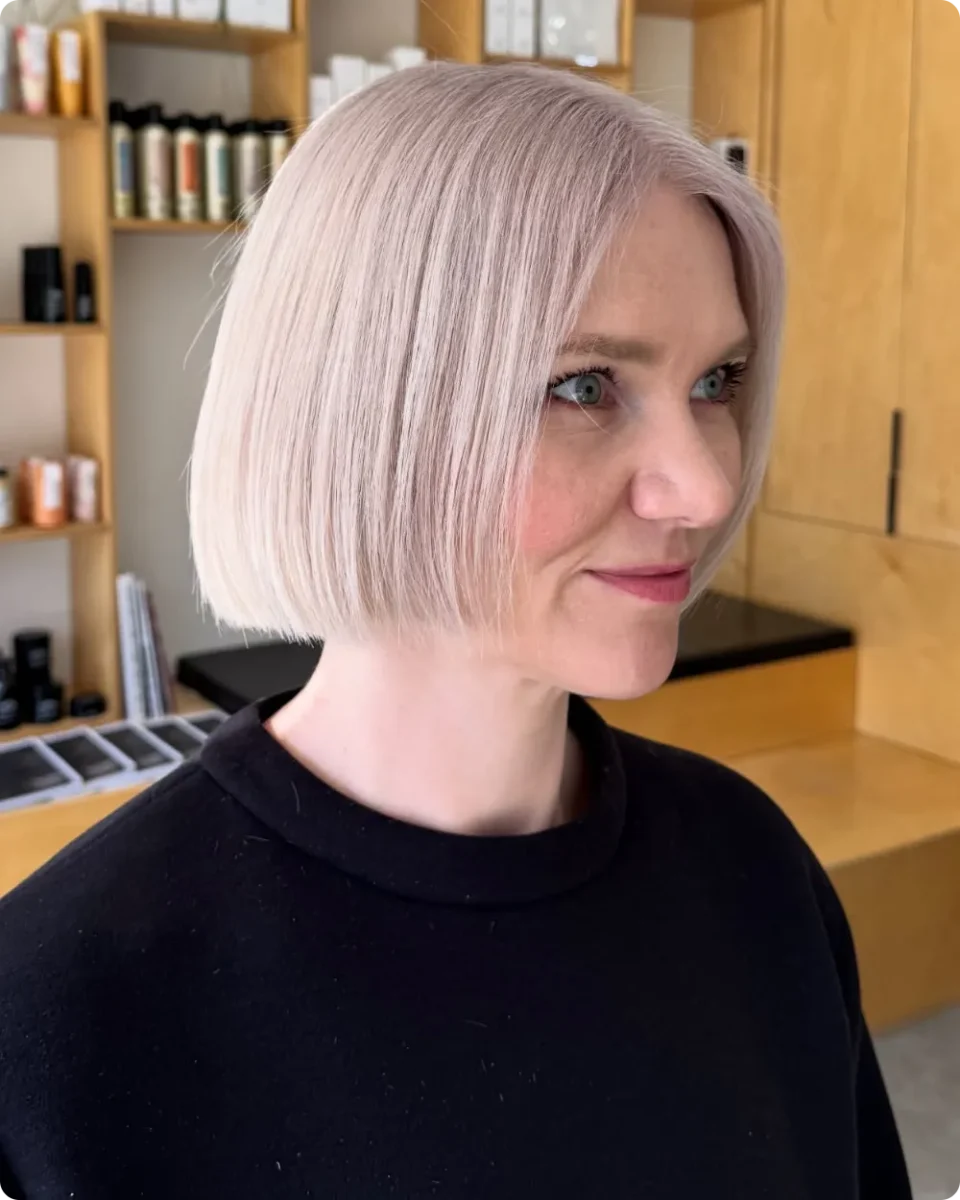 Sleek pearl blonde blunt bob cut at the jaw with the ends curving in