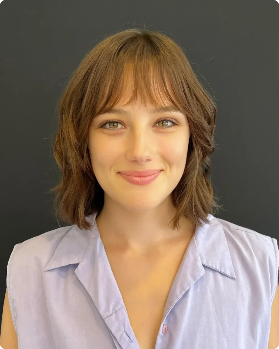 Auburn brown shaggy bob with a full fringe that skims the eyebrows
