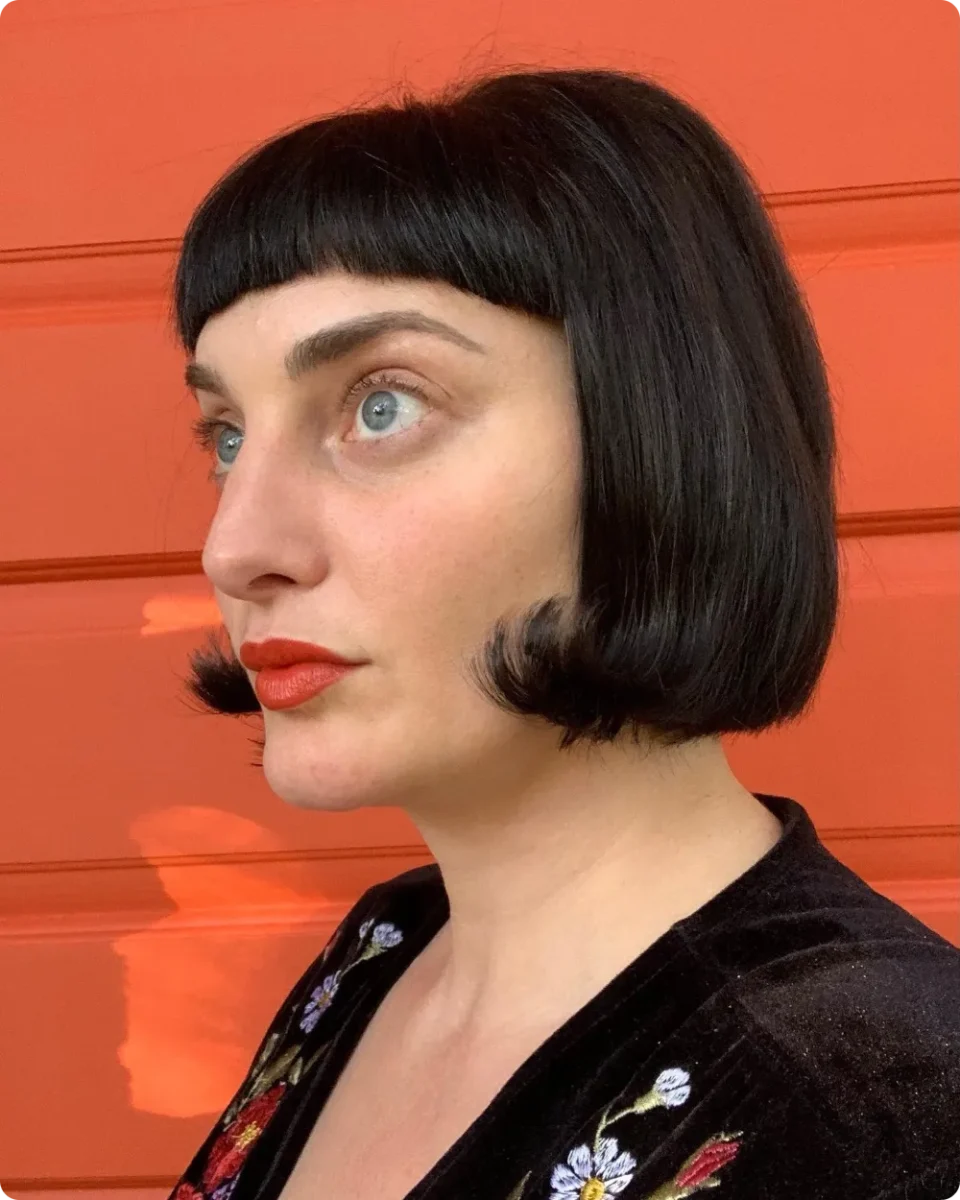 Jet black vintage bob with a micro fringe and ends rolled under at the jaw
