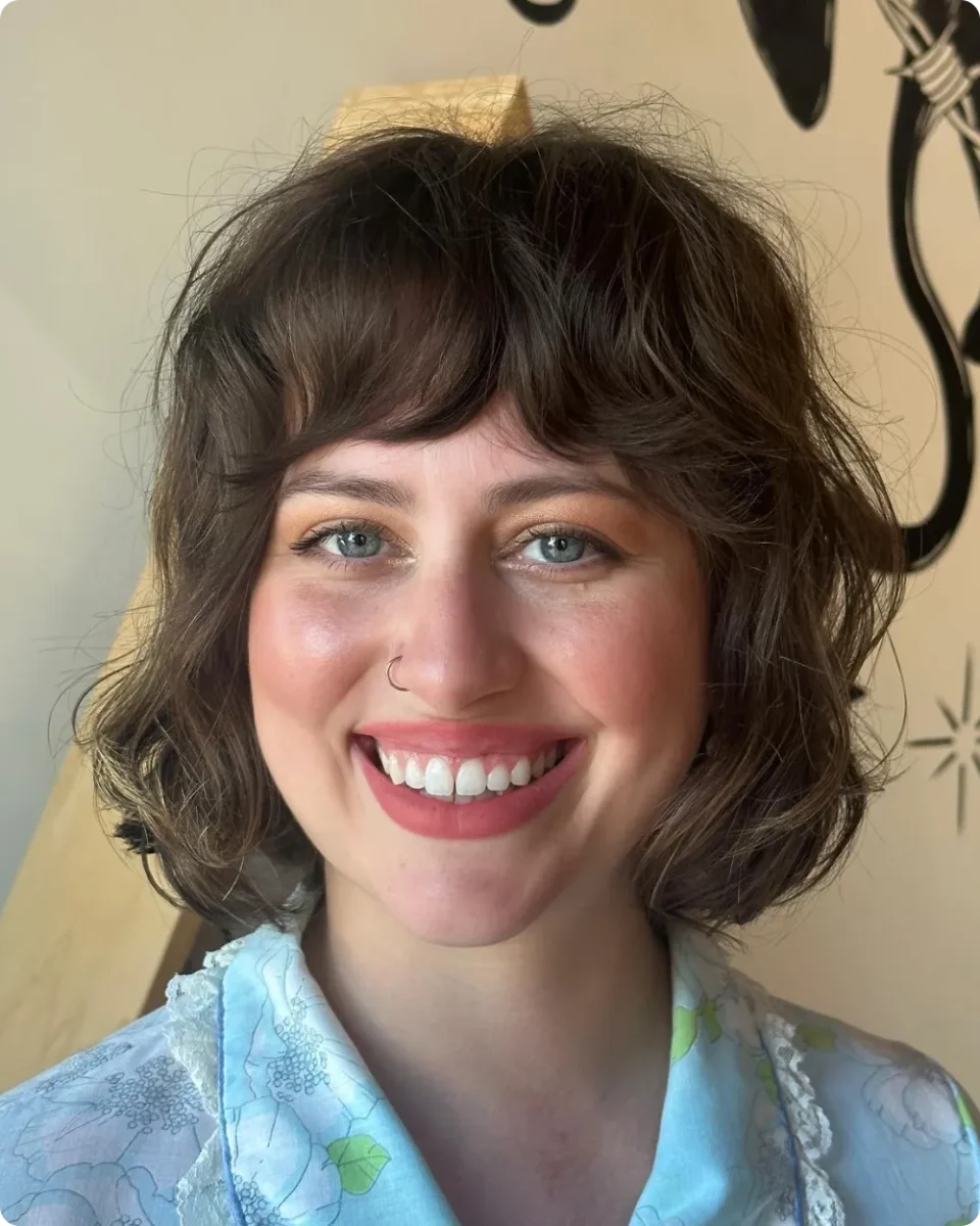 Medium brown wavy bob with a short curved fringe and volume at the crown